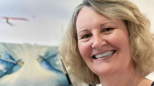 Artist Cassie Holmes in front of artwork